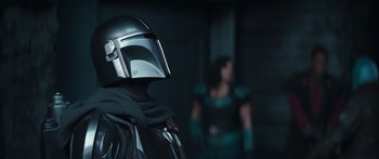 Movie still from “The Mandalorian” (2019), created by Jon Favreau – A person wearing a star wars helmet; Close Up shot, Low angle