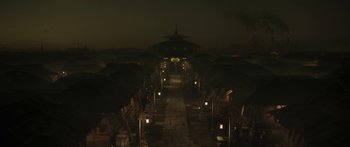 Movie still from “The Mandalorian” (2019), created by Jon Favreau – An outdoor area with a walkway and lights at night time; Extreme Wide shot, High angle
