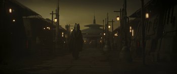 Movie still from “The Mandalorian” (2019), created by Jon Favreau – A person walking in the dark at night; Wide shot, Low angle