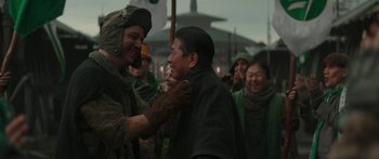 Movie still from “The Mandalorian” (2019), created by Jon Favreau – A group of people standing around each other in a crowd; Medium shot, Over the shoulder angle