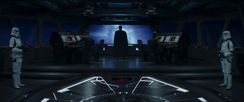 Movie still from “The Mandalorian” (2019), created by Jon Favreau – A man standing in front of a large screen; Wide shot, Low angle