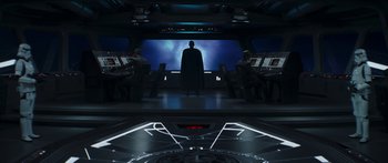 Movie still from “The Mandalorian” (2019), created by Jon Favreau – A group of people sitting in front of a large screen; Wide shot, Low angle