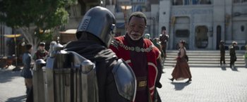 Movie still from “The Mandalorian” (2019), created by Jon Favreau – A man in a red and black costume and a man in a black and red costume; Medium shot, Over the shoulder angle