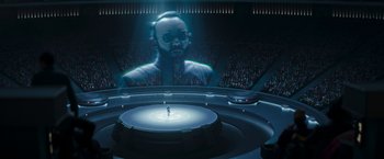 Movie still from “The Mandalorian” (2019), created by Jon Favreau – A man standing in front of an audience in front of a large screen; Extreme Wide shot, High angle