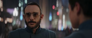 Movie still from “The Mandalorian” (2019), created by Jon Favreau – A man with a beard wearing glasses and a jacket; Close Up shot, Over the shoulder angle