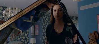 A woman standing in front of a mirror holding an umbrella