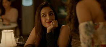 A beautiful woman with a diamond ring sitting in a chair