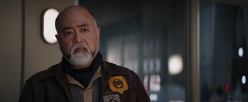 Movie still from “The Mandalorian” (2019), created by Jon Favreau – An older man with a beard wearing a leather jacket; Close Up shot, Low angle