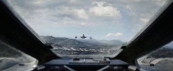 An airplane is flying in the sky over a mountain range