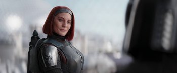 Movie still from “The Mandalorian” (2019), created by Jon Favreau – A woman with red hair is wearing armor; Close Up shot, Over the shoulder angle