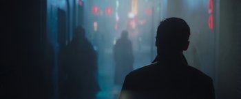 Movie still from “The Mandalorian” (2019), created by Jon Favreau – A man standing in the middle of a street at night; Medium shot, Over the shoulder angle