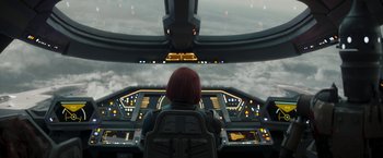 Movie still from “The Mandalorian” (2019), created by Jon Favreau – A woman sitting in a cockpit looking out at the sky; Extreme Wide shot, High angle