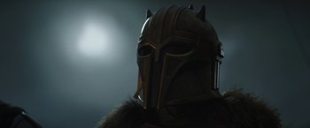 Movie still from “The Mandalorian” (2019), created by Jon Favreau – The face of a person wearing a viking helmet; Close Up shot, Low angle