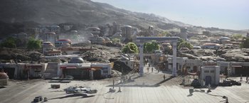 Movie still from “The Mandalorian” (2019), created by Jon Favreau – A group of people standing on top of a dirt hill; Extreme Wide shot, High angle