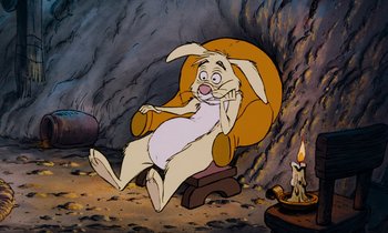 Movie still from “The Many Adventures of Winnie the Pooh” (1977), directed by John Lounsbery – An animated rabbit sitting in a chair next to a fire; Wide shot, High angle