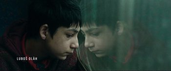 Movie still from “The Marco Effect” (2021), directed by Martin Zandvliet – A young boy looking at his reflection in a mirror; Close Up shot, Low angle