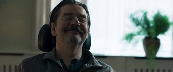 Movie still from “The Marco Effect” (2021), directed by Martin Zandvliet – A person with long hair and a mustache; Close Up shot, Low angle