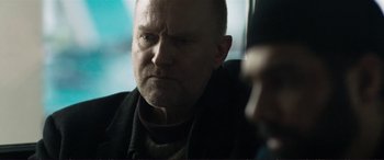 Movie still from “The Marco Effect” (2021), directed by Martin Zandvliet – A man with a shaved head and a beard; Close Up shot, Over the shoulder angle