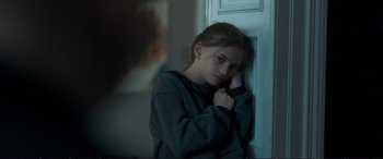 Movie still from “The Marco Effect” (2021), directed by Martin Zandvliet – A young girl leaning against a wall with her hand on her head; Close Up shot, Over the shoulder angle