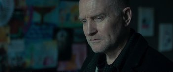 Movie still from “The Marco Effect” (2021), directed by Martin Zandvliet – A person wearing a suit and tie; Close Up shot, Over the shoulder angle