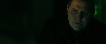 Movie still from “The Marco Effect” (2021), directed by Martin Zandvliet – A man in a black shirt is in the dark; Close Up shot, Low angle