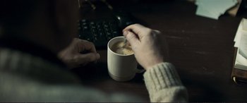 Movie still from “The Marco Effect” (2021), directed by Martin Zandvliet – A person is holding a cup of hot chocolate; Extreme Close Up shot, High angle