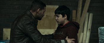 Movie still from “The Marco Effect” (2021), directed by Martin Zandvliet – A man and a boy are touching each other's hands; Medium shot, Over the shoulder angle