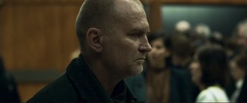 Movie still from “The Marco Effect” (2021), directed by Martin Zandvliet – A man with a shaved head and a goatee looking to his left; Close Up shot, Over the shoulder angle