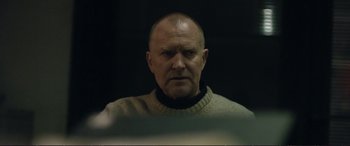 Movie still from “The Marco Effect” (2021), directed by Martin Zandvliet – A man in a sweater looking at the camera; Close Up shot, Low angle