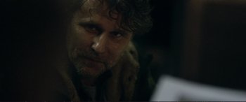 Movie still from “The Marco Effect” (2021), directed by Martin Zandvliet – A person with a dog in the dark; Close Up shot, Over the shoulder angle