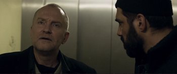 Movie still from “The Marco Effect” (2021), directed by Martin Zandvliet – Two men are talking in a elevator; Close Up shot, Over the shoulder angle