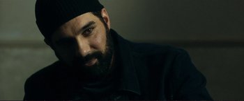 Movie still from “The Marco Effect” (2021), directed by Martin Zandvliet – A man with a beard wearing a black jacket; Close Up shot, Over the shoulder angle
