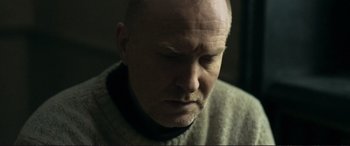 Movie still from “The Marco Effect” (2021), directed by Martin Zandvliet – A man with a bald head is looking at the camera; Close Up shot, Over the shoulder angle