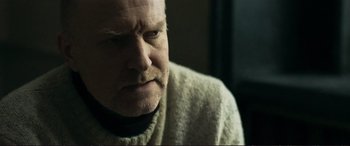 Movie still from “The Marco Effect” (2021), directed by Martin Zandvliet – An older man wearing a white sweater looking at the camera; Close Up shot, Over the shoulder angle