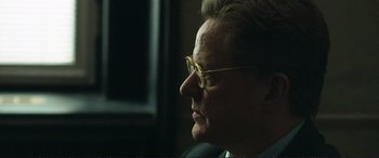 Movie still from “The Marco Effect” (2021), directed by Martin Zandvliet – An older man wearing glasses looking out a window; Close Up shot, Over the shoulder angle