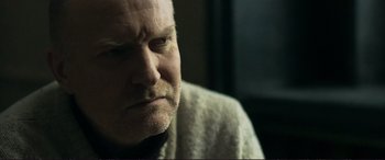 Movie still from “The Marco Effect” (2021), directed by Martin Zandvliet – A man's face in a white robe; Close Up shot, Low angle