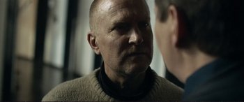 Movie still from “The Marco Effect” (2021), directed by Martin Zandvliet – An older man wearing a brown sweater looking at the camera; Close Up shot, Over the shoulder angle