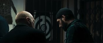 Movie still from “The Marco Effect” (2021), directed by Martin Zandvliet – A man with a beard is looking at another man with a shaved head; Medium shot, Over the shoulder angle