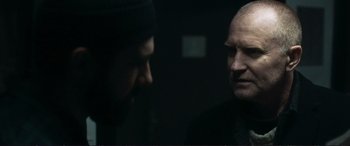 Movie still from “The Marco Effect” (2021), directed by Martin Zandvliet – Two men are facing each other in the dark; Close Up shot, Over the shoulder angle