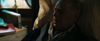 Movie still from “The Marco Effect” (2021), directed by Martin Zandvliet – An older man sitting in a chair with his eyes closed; Close Up shot, High angle