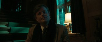 Movie still from “The Marco Effect” (2021), directed by Martin Zandvliet – A man wearing a suit and tie in front of a window; Close Up shot, Over the shoulder angle