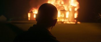 Movie still from “The Marco Effect” (2021), directed by Martin Zandvliet – A man in front of a burning building; Close Up shot, Over the shoulder angle