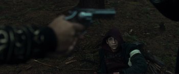 Movie still from “The Marco Effect” (2021), directed by Martin Zandvliet – A man in a hooded jacket is holding a gun pointed at him; Close Up shot, Over the shoulder angle