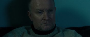 Movie still from “The Marco Effect” (2021), directed by Martin Zandvliet – An older man with a goatee looking at the camera; Close Up shot, Low angle