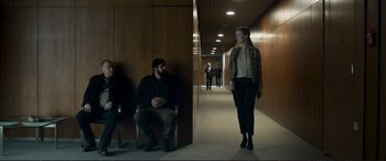 Movie still from “The Marco Effect” (2021), directed by Martin Zandvliet – A man and a woman are walking down a hallway; Wide shot, Low angle
