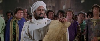 Movie still from “The Message” (1976), directed by Moustapha Akkad – A man in a white turban is holding a piece of paper; Close Up shot, Low angle