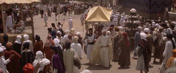 Movie still from “The Message” (1976), directed by Moustapha Akkad – A group of people walking down a street; Extreme Wide shot, High angle