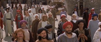 Movie still from “The Message” (1976), directed by Moustapha Akkad – A group of men in traditional clothing walking down a street; Wide shot, High angle