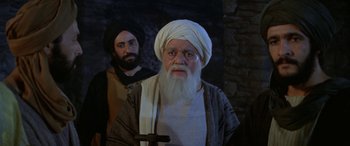 Movie still from “The Message” (1976), directed by Moustapha Akkad – An old man with a beard and a turban and a man with a beard; Medium shot, Over the shoulder angle
