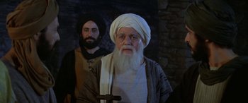 Movie still from “The Message” (1976), directed by Moustapha Akkad – A man with long white beard standing next to another man; Medium shot, Over the shoulder angle